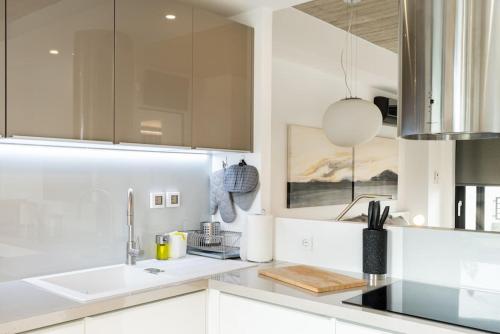 eine Küche mit weißen Schränken und einem Waschbecken in der Unterkunft The HostMaster Persephone Yellow Opulence 2nd floor in Athen