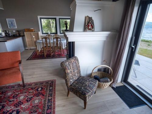 sala de estar con chimenea y silla en Sjøhuset, en Løding