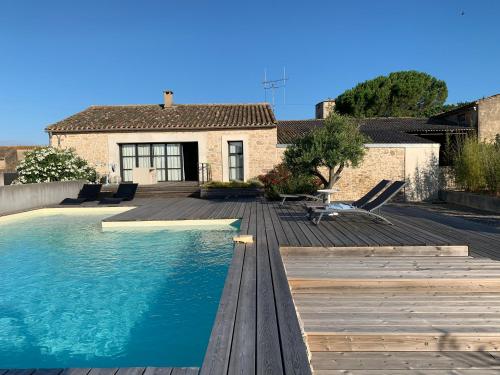 une maison avec une piscine et une terrasse en bois dans l'établissement Villa de Charme - Vue sur les Pyrénées, à Ventenac-Cabardès