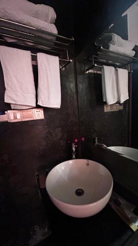 a bathroom with a white sink and towels at Family Hotel Zhangjiajie in Zhangjiajie