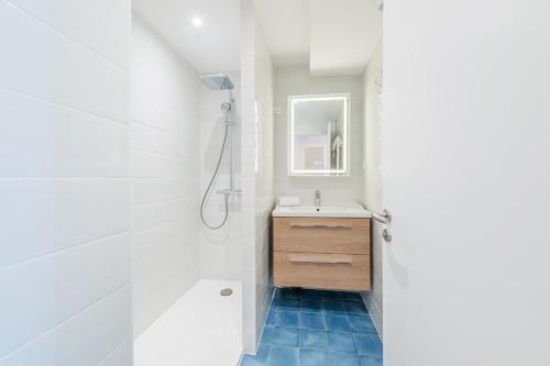 une salle de bain blanche avec un lavabo et un miroir dans l'établissement Le Strasbourgeois - Appt 60m² - 6 voyageurs, à Strasbourg