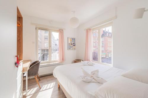 une chambre blanche avec un lit et deux fenêtres dans l'établissement Le Strasbourgeois - Appt 60m² - 6 voyageurs, à Strasbourg