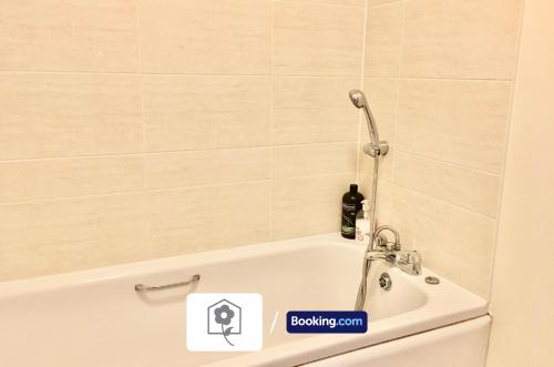 a bath tub in a bathroom with a shower at Garden Apartment near New Forest By Your Stay Solutions Short Lets & Serviced Accommodation Netley Southampton With Free Wi-Fi in Totton