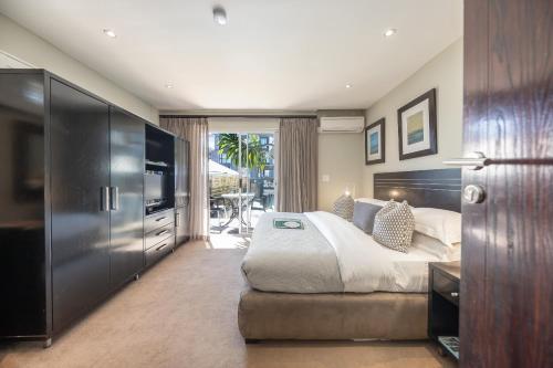 a bedroom with a large bed and a television at O on Kloof Boutique Hotel & Spa in Cape Town