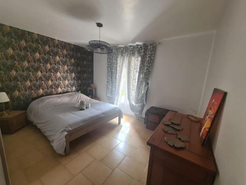 une chambre avec un lit, une table et une fenêtre dans l'établissement Magnifique villa - 9 personnes - Proche de la mer, à Saint-Brès