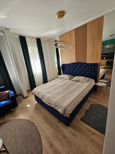 een slaapkamer met een bed met een blauw hoofdeinde bij POT Apartments in Târgu-Mureş