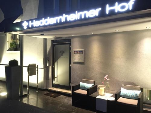 a hotel entrance with two chairs and a sign at Hotel Heddernheimer Hof in Frankfurt/Main