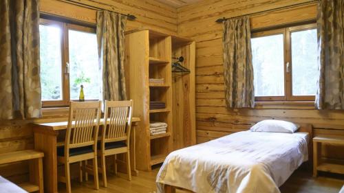 Schlafzimmer mit einem Bett, einem Schreibtisch und Fenstern in der Unterkunft Toosikannu Holiday Center and Wildlife Park in Käru