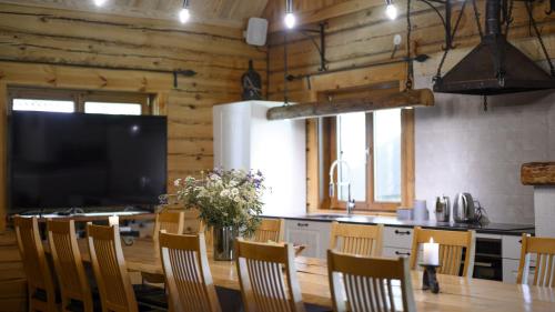 cocina con mesa con sillas y TV en Toosikannu Holiday Center and Wildlife Park, en Käru