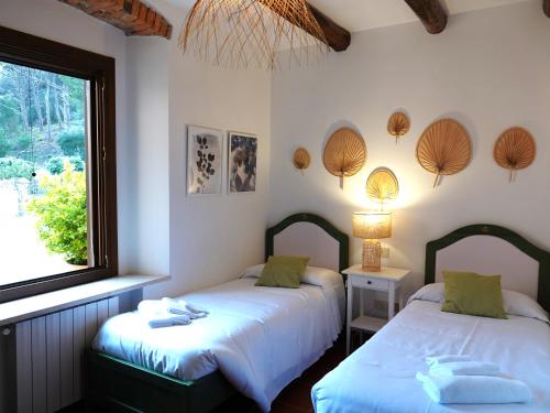 two beds in a room with a window at Agriturismo Pimpinnacolo in Porto Ercole