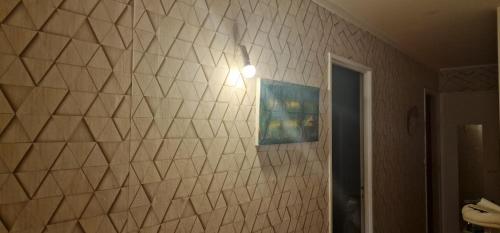una pared de azulejos blancos con una luz en ella en Location ideal J.o du 15 juin au 15 Aout., en Chaville
