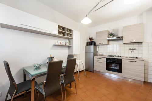 Benvenuti a casa في بيزا: مطبخ وغرفة طعام مع طاولة وكراسي