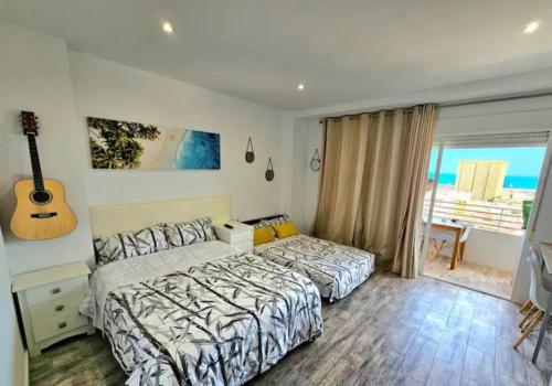 a bedroom with a bed and a guitar on the wall at Mirador in Alicante