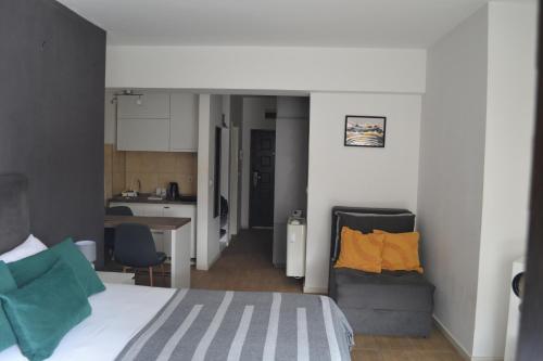 a bedroom with a bed and a couch and a kitchen at Urban Apartment in Niš