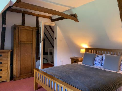 een slaapkamer met een groot bed met blauwe kussens bij Beaumont's Cottage in Cambridge
