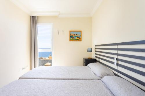 Schlafzimmer mit einem großen Bett und Meerblick in der Unterkunft Home2Book Amazing Sea Views & Terrace, El Porís in Poris de Abona