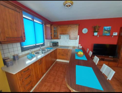 een keuken met een blauw aanrecht en rode muren bij Vivienda Vacacional Noni, Los Llanos de Aridane in Los Llanos de Aridane