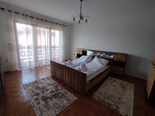 a bedroom with a bed and a large window at REA Home Visoko in Visoko