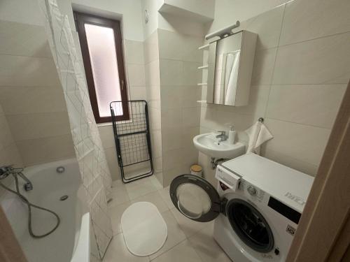 a white bathroom with a washing machine in it at DunaVera Apartman in Budapest