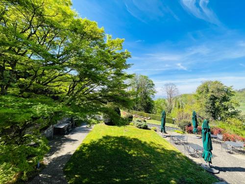 a garden with lawn chairs and umbrellas at Hotel Schlossberg in Badenweiler
