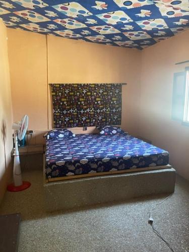 1 dormitorio con cama y techo artesonado en KEUR Junior, en Ndangane