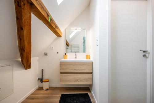 ein Bad mit einem Waschbecken und einem Spiegel in der Unterkunft Une petite vue sur le Paradis in Orbey
