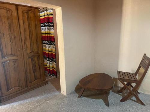 a wooden chair and a table in a room with a closet at KEUR Junior in Ndangane