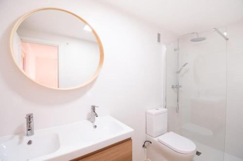 Baño blanco con lavabo y espejo en Apartamento en Parque Central en Tarragona