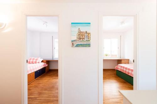 a room with two beds and two windows at Apartamento en Parque Central in Tarragona