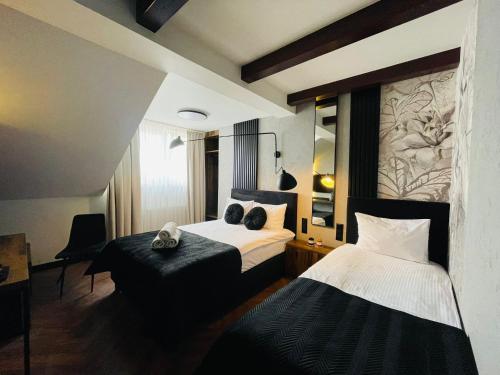 プジャスニシュにあるホテル ミレニアムのベッド2台とテーブルが備わるホテルルームです。