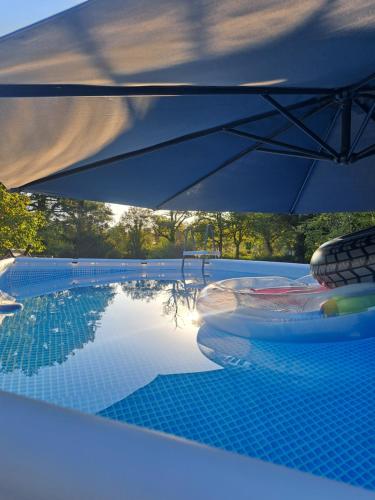 - une piscine avec un parasol dans l'établissement Chez Nous, à Brigueuil-le-Chantre