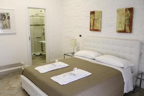 ein Schlafzimmer mit einem Bett mit zwei Handtüchern darauf in der Unterkunft Attico Luxury B&B in Santa Maria Capua Vetere