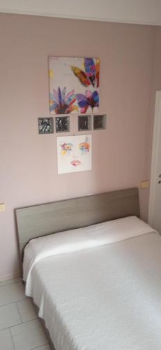 ein Bett in einem Schlafzimmer mit Gemälden an der Wand in der Unterkunft Little Moon in Fontana Liri