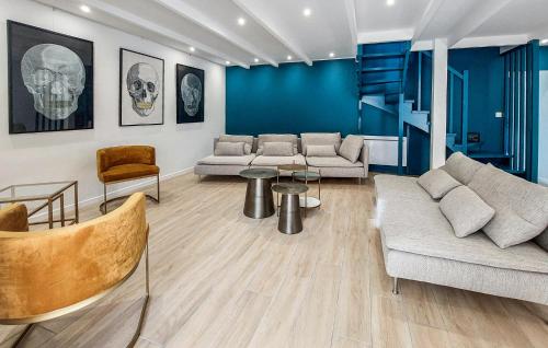 a living room with two couches and a blue wall at 4 Bedroom Amazing Home In Plouézec in Plouézec