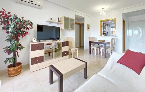 a living room with a couch and a tv and a table at Stunning Apartment In Oropesa Del Mar in Oropesa del Mar