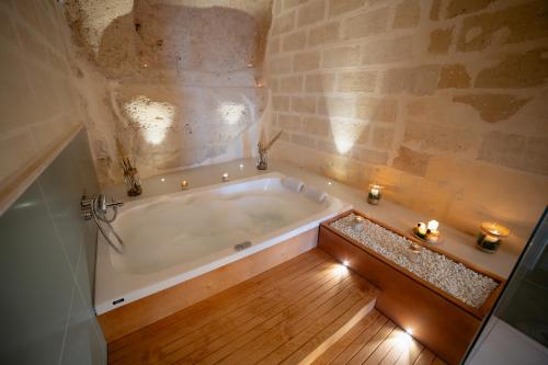 a bath tub in a bathroom with candles on the floor at Endea Suite Rooms & Lounge SPA in Matera