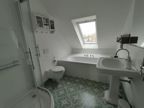 uma casa de banho com uma banheira, um WC e um lavatório. em Fährhaus Wittower Fähre em Wiek auf Rügen