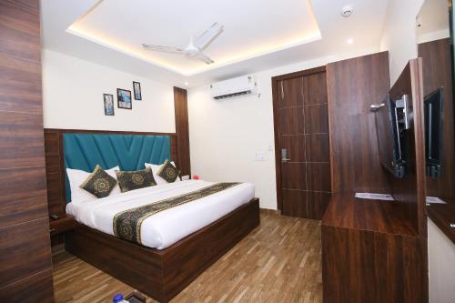a hotel room with a bed and a tv at Hotel East Wood Amritsar in Amritsar