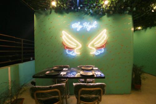 a table with chairs and a sign with wings at Hotel East Wood Amritsar in Amritsar