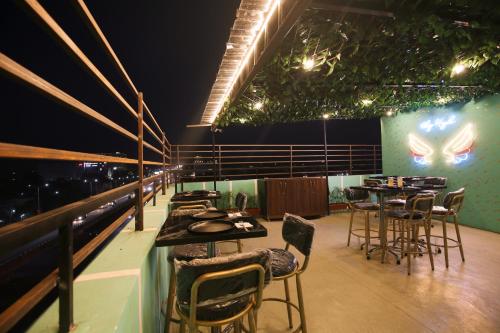 a restaurant with tables and chairs on a balcony at Hotel East Wood Amritsar in Amritsar