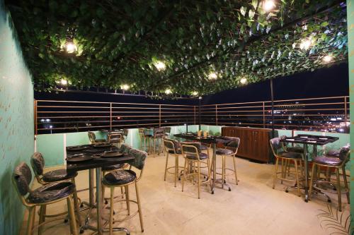 a restaurant with tables and chairs and lights on the ceiling at Hotel East Wood Amritsar in Amritsar