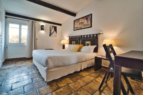 a bedroom with a large bed and a desk and a desk at Mas De Calabrun in Saintes-Maries-de-la-Mer