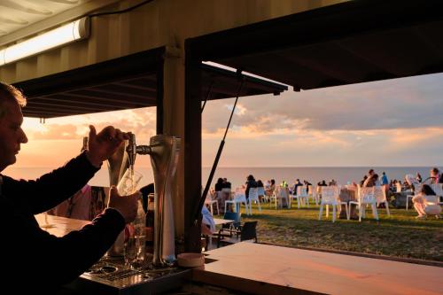 a woman sitting at a table with a drink at Hotel Gerra Mayor in San Vicente de la Barquera