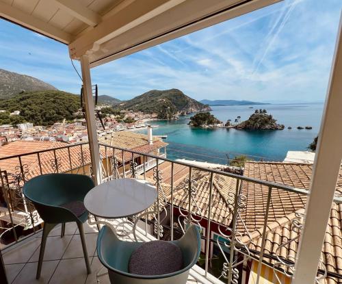 balcón con mesa, sillas y vistas al agua en Marina's House, en Parga