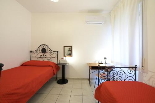 1 dormitorio con 2 camas, mesa y ventana en Casa Rosso Melograno, en Alassio