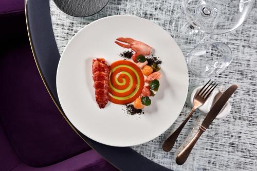 a white plate with food on a table at Villa Cortine Palace Relais Chateaux in Sirmione