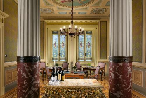 een eetkamer met een tafel en stoelen en een kroonluchter bij Villa Cortine Palace Hotel in Sirmione