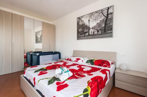 a bedroom with a bed with red flowers on it at Benvenuti a casa in Pisa