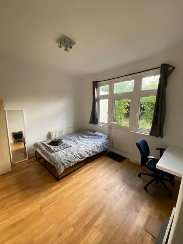 1 dormitorio con cama, escritorio y ventana en [ Mushroom Room ] Double bedroom in NW en Hendon