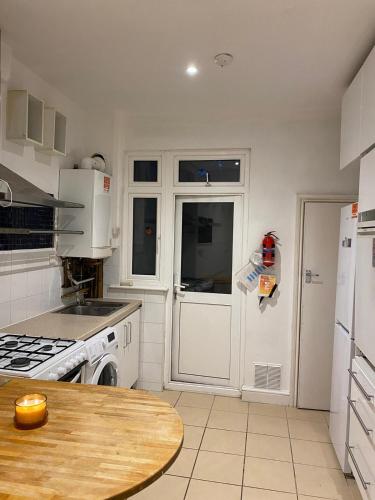 cocina con electrodomésticos blancos y mesa de madera en [ Mushroom Room ] Double bedroom in NW en Hendon